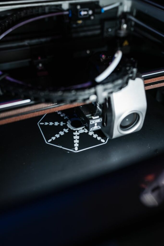 Detailed view of a 3D printer creating a precise object, showcasing advanced technology.