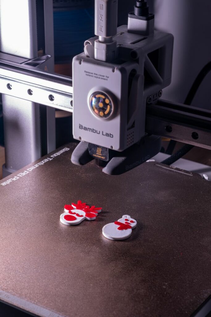Close-up of a 3D printer creating vibrant snowman decorations, embodying modern technology and festive spirit.